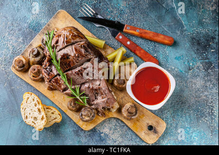 Ram grillés jambe avec champignons, légumes, épices sur une planche à découper. La viande halal et de l'alimentation. Vue d'en haut Banque D'Images