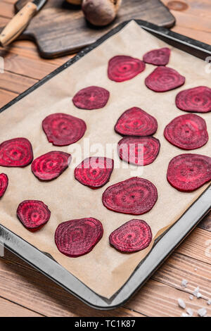 Plaque avec de délicieuses chips de betterave brut sur table en bois Banque D'Images