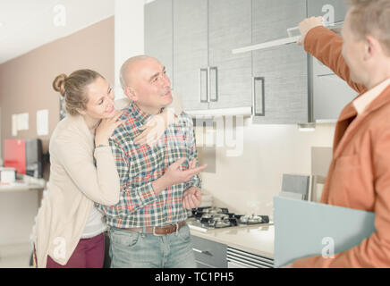 Shop assistant professionnel travaillant avec le client au magasin de meubles de cuisine Banque D'Images