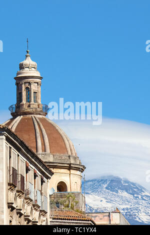 La photographie verticale capturant la magnifique coupole de la cathédrale catholique romaine de Sainte Agathe à Catane, Sicile, Italie. En arrière-plan célèbre volcan Etna avec de la neige sur le haut. Banque D'Images