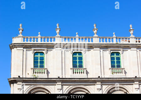 Close up photo de l'avant du bâtiment de l'université historique de Catane, Sicile, Italie. L'Université de Catane est la plus ancienne université sicilienne. La façade blanche, green windows, d'un balcon. Banque D'Images