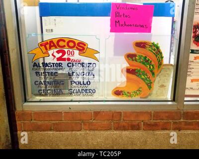 Inscription peinte à la main en anglais et en espagnol de la publicité 2 tacos dans un restaurant traditionnel de taqueria sur Roosevelt Avenue, Woodside, Queens, New York, mars 25, 2019. () Banque D'Images