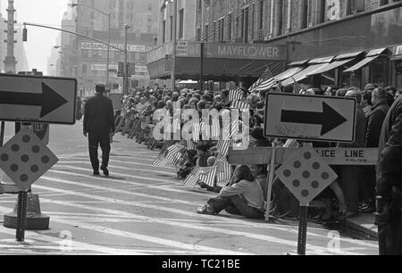 Un policier, à l'arrière, et d'une rangée de spectateurs avec des drapeaux américains, en attendant de voir la guerre du Vietnam Accueil liées à l'honneur Avec Parade, New York City, New York, mars 31, 1973. () Banque D'Images