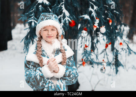 Portrait de jeune fille de neige. petite fille a gelé en hiver dans la forêt. l'enfant se réchauffe ses mains. Bonne Année Banque D'Images