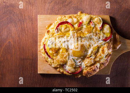 Oeufs cuits au four avec du fromage avec des légumes sur une tortilla sur une planche de bois. copy space Banque D'Images