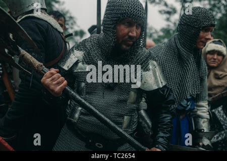 L'Escouade de combat de chevaliers médiévaux stand dans les armures et casques avec leurs haches et de lances. Banque D'Images