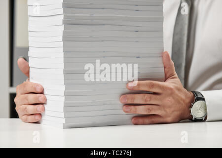 Businessman working dans un bureau, lit pile de livres et des rapports. Business concept de comptabilité financière. Banque D'Images