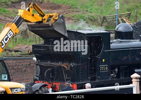 Un chariot télescopique JCB chargement de charbon en ex Great Western Railway pannier aucun réservoir de 7714 à Bridgnorth station sur la Severn Valley Railway Banque D'Images