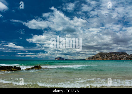 Plage Cantal Roig à Calpe, Alicante, Espagne. La ville de Benidorm à fond, et quelques maisons d'habitation Banque D'Images