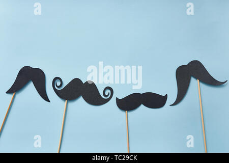 Carte de vœux de fête des pères avec emplacement pour le texte, moustaches noires sur fond de papier bleu. Vêtements taille basse pour la pose à plat Banque D'Images