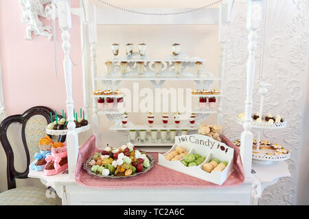 Candy bar magnifiquement servi sur la table blanche avec un des bonbons, des fruits, des macarons et autres desserts, assortiment de mariage de luxe Banque D'Images