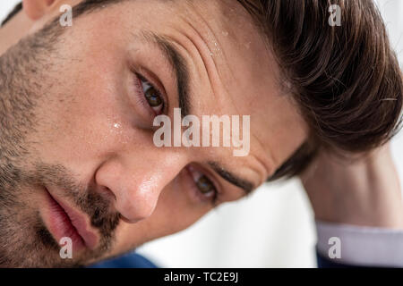 Portrait de épuisé bel homme avec transpiration visage souffrant de la chaleur on white Banque D'Images