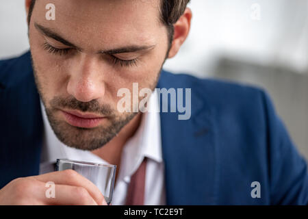 Beau barbu holding souffrant de la chaleur et de l'holding glass of water Banque D'Images