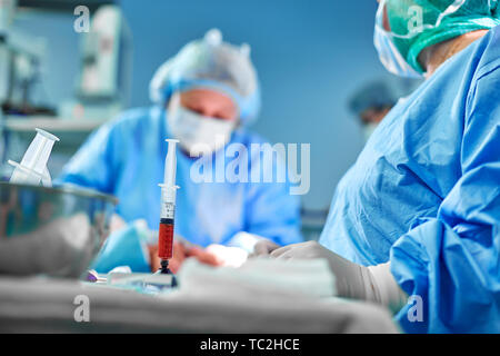 Tenir les mains d'une seringue de graisse et d'effectuer avec l'aide d'un outil de transfert de graisse dans la salle d'opération. Chirurgie Concept, la beauté, la chirurgie plastique, de l'obésité Banque D'Images