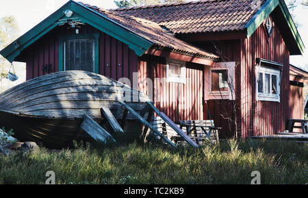 Bateau en bois posés à l'extérieur bois traditionnel falu maison rouge en hiver, Sandhamn island, archipel de Stockholm, Suède, Scandinavie Banque D'Images