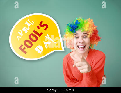 Femme drôle avec perruque April Fools' day celebration sur un fond de couleur Banque D'Images
