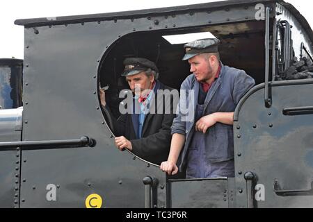 Conducteur et pompier à la recherche hors de la cabine de l'ancien réservoir 7714 GWR pannier à Kidderminster station sur la Severn Valley Heritage Railway Banque D'Images