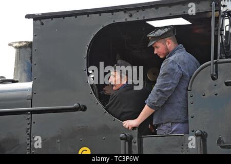 Conducteur et pompier à la recherche hors de la cabine de l'ancien réservoir 7714 GWR pannier à Kidderminster station sur la Severn Valley Heritage Railway Banque D'Images