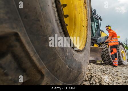 Location d'équipement lourd Concept Photo. La machine et l'opérateur dans un arrière-plan. Thème industriel. Machine de construction routière. Banque D'Images