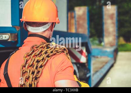 Concept de charge surdimensionnée. Caucasian Worker avec les grandes chaînes sur son épaule. L'industrie des transports. Banque D'Images