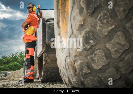 Caucasian Road Roller Travailleur de l'opérateur dans la trentaine. La construction de l'équipement lourd. Banque D'Images