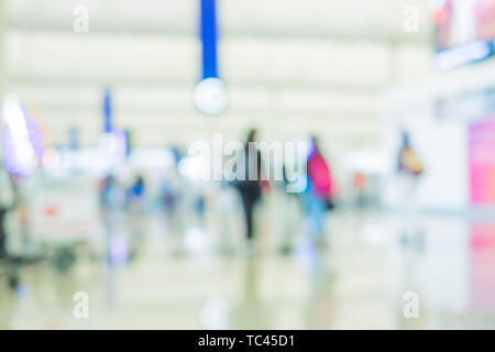 Arrière-plan flou,Voyageur avec bagages enregistrés à la borne Départ Arrivée à l'aéroport avec concept de transport,lumière effet bokeh Banque D'Images