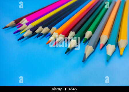 Un crayon de couleur sont soigneusement disposées dans un fond bleu