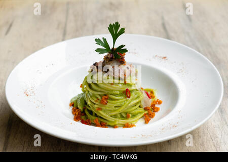 Close up of colorful brocoli vert nouilles Spaghetti pâtes aux fruits de mer, poissons carpaccio, crème d'anchois, le persil frais, l'ail fait maison, crumble orange, p Banque D'Images