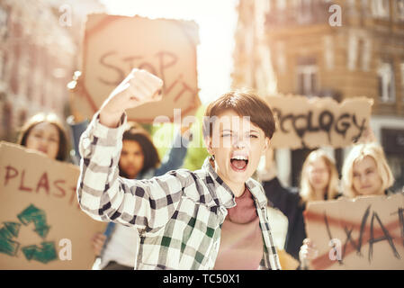 Lutter pour nettoyer la terre. Jeune femme forte et proteste pour l'écologie avec groupe de militantes en marchant sur la route. Concept de l'écologie. Grève du climat. Concept de protestation. Concept de la révolution Banque D'Images