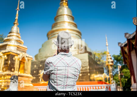 Un touriste prend une photo du temple orné au célèbre temple thaïlandais Wat Phra Sing Chiang Mai, Thaïlande. Banque D'Images