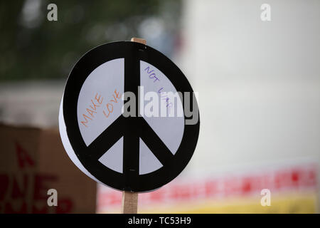 Une personne est titulaire d'un signe de la paix bannière lors d'une manifestation Banque D'Images