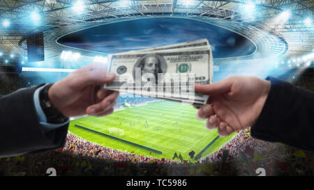 Transfert d'argent entre deux mains au stade de soccer Banque D'Images