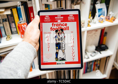 Paris, France - Apr 15, 2019 : lecture sur iPad Apple Pro News Plus d' journal numérique sur la couverture de France Football Messi et Ronaldo personnages de baisers Banque D'Images