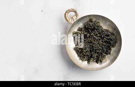 Black Caviar Vue de dessus ou de télévision. Bol de caviar noir sur blanc en arrière-plan. L'espace de copie pour le texte. Banner Banque D'Images