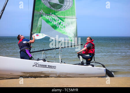 Deux marins la préparation de Hobie Cat, petit bateau à voile sur la plage le long de la côte de la mer du Nord Banque D'Images