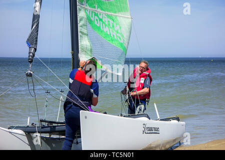 Deux marins la préparation de Hobie Cat, petit bateau à voile sur la plage le long de la côte de la mer du Nord Banque D'Images