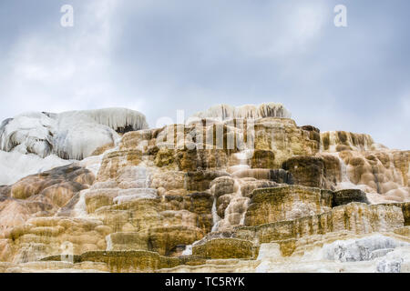 Les dépôts de minéraux et de calcium dans le cadre d'un cloiudy ciel à Mammoth Hot Springs dans le Parc National de Yellowstone. Banque D'Images