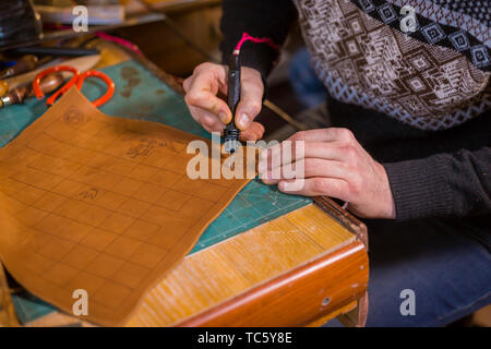 Skinner faire détails décoratifs sur terrain de jeu en cuir Banque D'Images