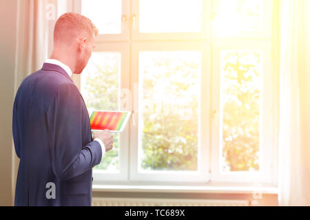 Consultant en énergie mâle avec une photo thermographique de windows sur son ordinateur tablette, copy space Banque D'Images