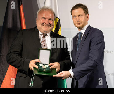 05 juin 2019, Saxe, Dresde : Michael Kretschmer (CDU, r), le premier ministre de Saxe, la remise des prix de l'Ordre du mérite à Saxon Jörg Junhold, directeur du Zoo de Leipzig, dans le Fürstengalerie dans le Residenzschloss. Kretschmer awards le Saxon Ordre de mérite à 17 citoyens. Ce prix est destiné à honorer des personnes qui ont démontré un engagement remarquable dans les domaines politique, économique, culturel, social, sociétal ou champs d'honneur. Photo : Robert Michael/dpa-Zentralbild/dpa Banque D'Images