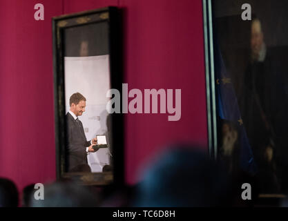 05 juin 2019, Saxe, Dresde : Michael Kretschmer (CDU, l), premier ministre de Saxe, se reflète dans une peinture au cours d'une présentation de l'ordre de mérite Saxon dans le Fürstengalerie dans le Residenzschloss. Kretschmer awards le Saxon Ordre de mérite à 17 citoyens. Ce prix est destiné à honorer des personnes qui ont démontré un engagement remarquable dans les domaines politique, économique, culturel, social, sociétal ou champs d'honneur. Photo : Robert Michael/dpa-Zentralbild/dpa Banque D'Images