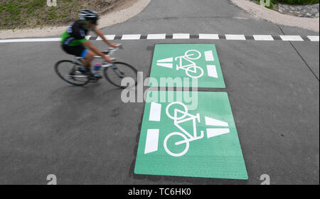 Egelsbach, Allemagne. Le 05 juin, 2019. Un cycliste se déplace sur une section du nouveau cycle voie rapide près de Egelsbach sur un marquage appliqué à l'asphalte. La première terminée 3,6 kilomètres connecter Darmstadt-Wixhausen et Egelsbach. Les quelque 30 kilomètres de liaison entre Francfort et Darmstadt est d'être achevé d'ici 2022 (dpa 'Hesse express du premier cycle est en croissance - Inauguration de la section"). Credit : Arne Dedert/dpa/Alamy Live News Banque D'Images