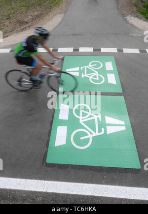 Egelsbach, Allemagne. Le 05 juin, 2019. Un cycliste se déplace sur une section du nouveau cycle voie rapide près de Egelsbach sur un marquage appliqué à l'asphalte. La première terminée 3,6 kilomètres connecter Darmstadt-Wixhausen et Egelsbach. Les quelque 30 kilomètres de liaison entre Francfort et Darmstadt est d'être achevé d'ici 2022 (dpa 'Hesse express du premier cycle est en croissance - Inauguration de la section"). Credit : Arne Dedert/dpa/Alamy Live News Banque D'Images