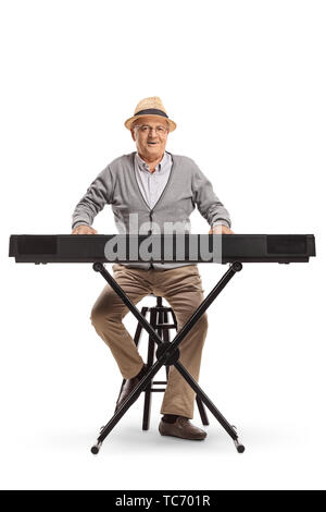 Full Length portrait of a senior man sitting et jouer d'un clavier isolé sur fond blanc Banque D'Images