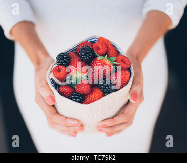 Fruits Fruits juteux et en bonne santé dans les mains de la femme avec robe blanche Banque D'Images