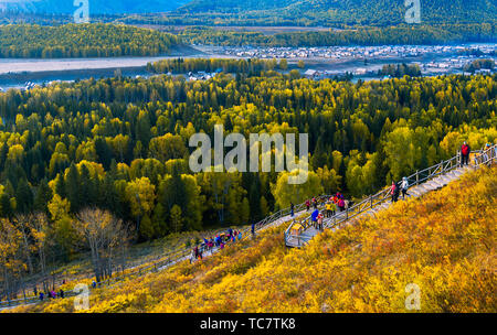 Dans Wo Mu Village, Xinjiang, tôt le matin, les touristes regarder le matin sur la route du pont à chevalets en bois. Banque D'Images