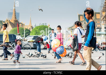 Les familles profitent d'une journée pour nourrir les pigeons, acheter des jouets et des ballons et marcher le long de la promenade en face du Palais Royal Phnom Penh Cambodgiens Banque D'Images