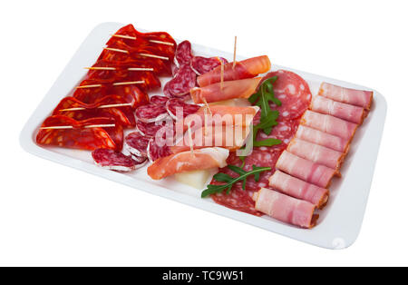 Charcuterie appétissant de l'espagnol, jambon séché à l'air sec épicée saucisses et bacon avec olives et roquette sur plaque blanche. Plus isolé sur fond blanc Banque D'Images