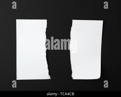 Déchiré à moitié vide dans une feuille de papier blanc sur fond noir, Close up Banque D'Images