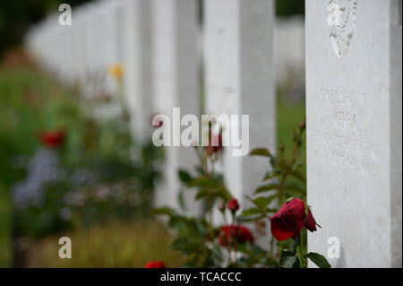 Fleurs à côté de tombes à la Royal British Legion's Service du souvenir, à la Commonwealth War Graves Commission Cemetery, à Bayeux, France, dans le cadre de commémorations pour le 75e anniversaire du débarquement. Banque D'Images